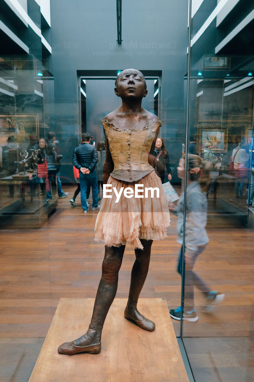 WOMAN STANDING IN SHOPPING MALL