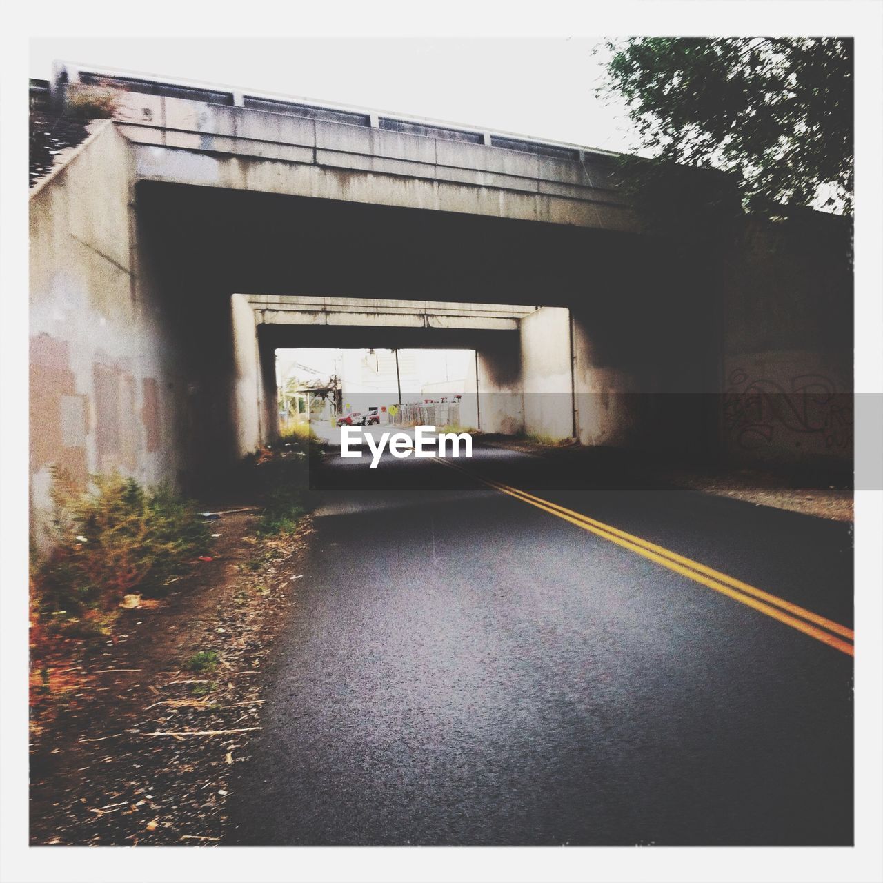 Bridge over empty road against clear sky