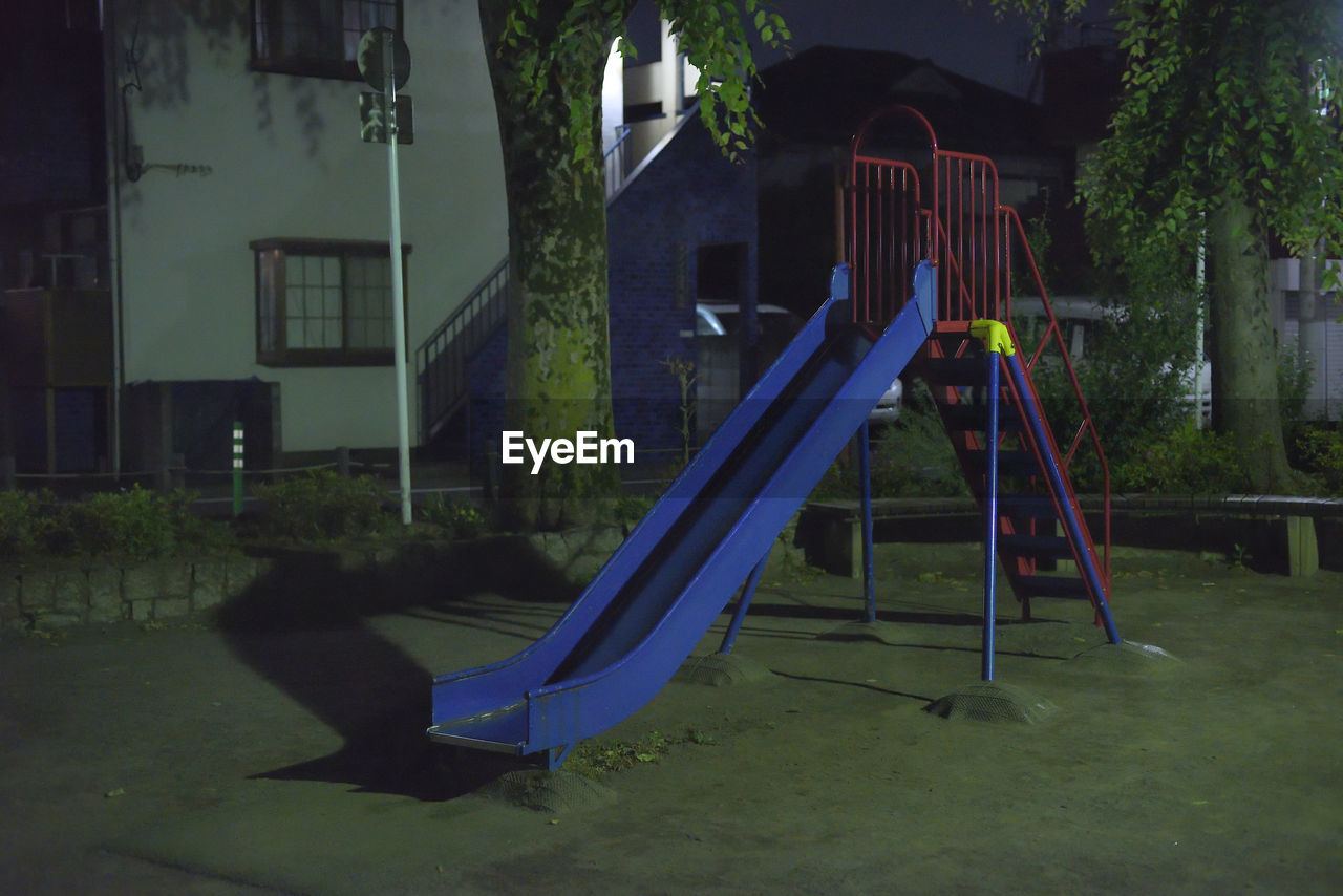 Empty playground against trees in park