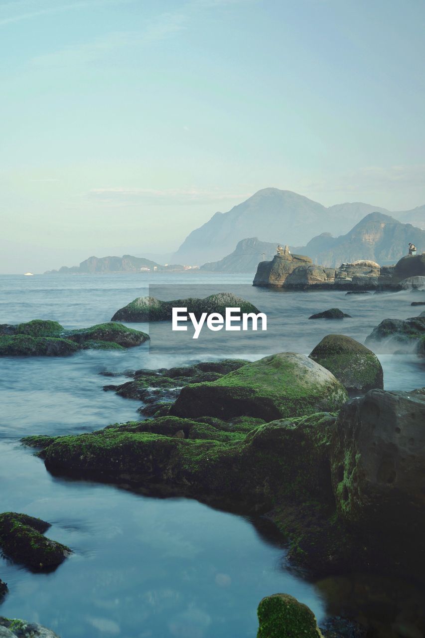 Scenic view of river and mountains against sky