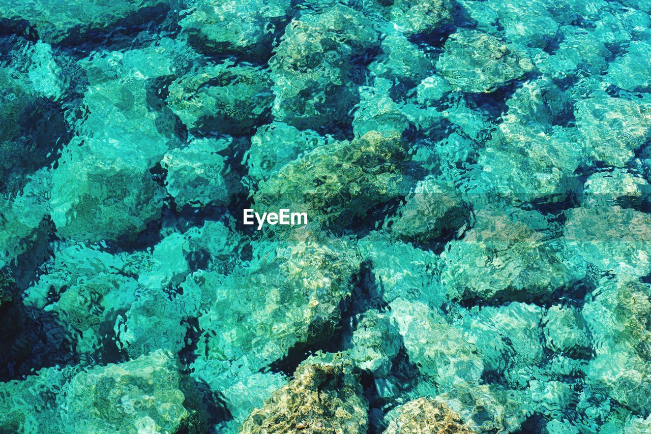 FULL FRAME SHOT OF ROCKS AT SEA SHORE