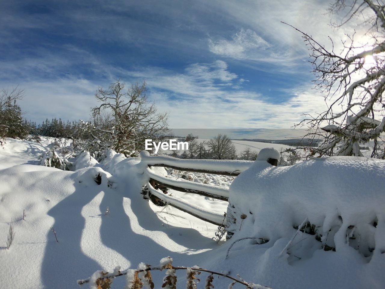 Snow covered field against sky