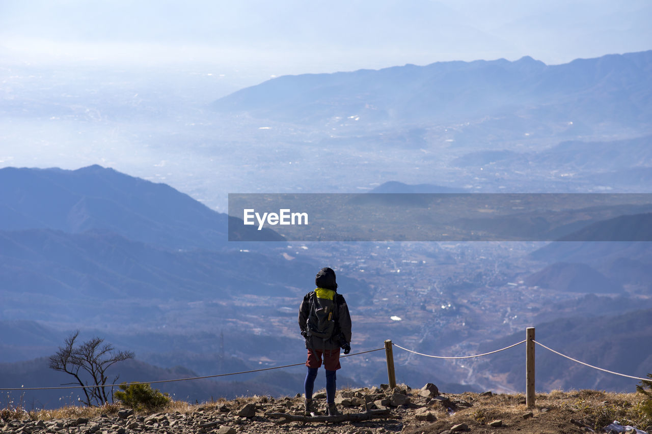 Rear view of woman standing on mountain