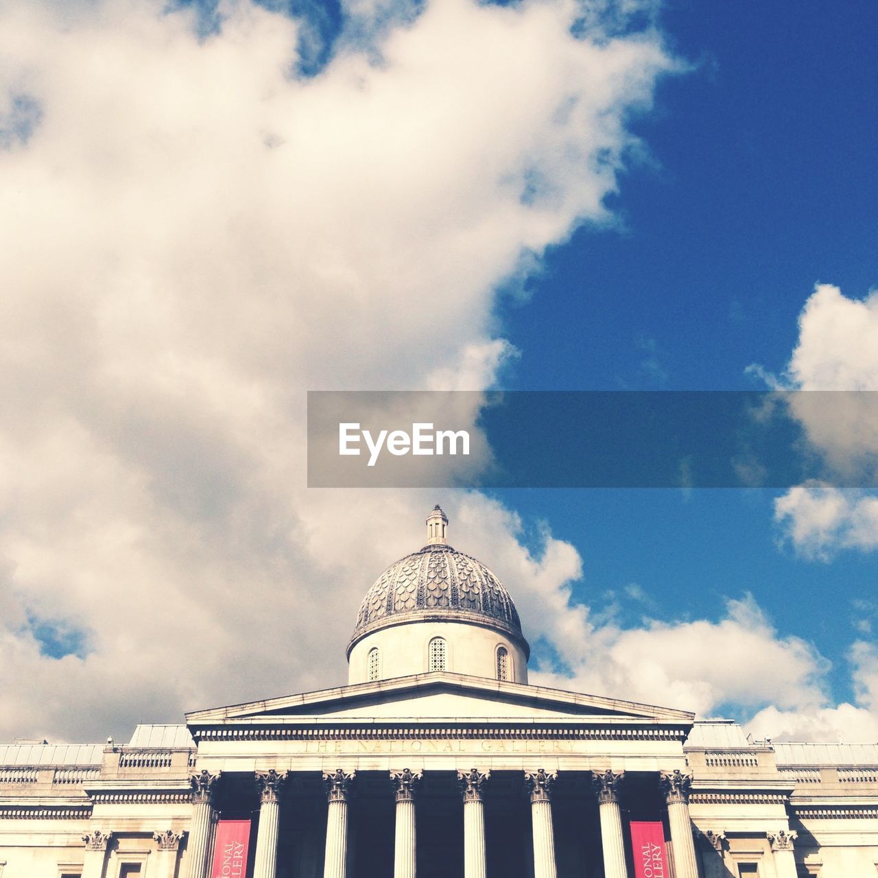 Low angle view of parliament building against cloudy sky