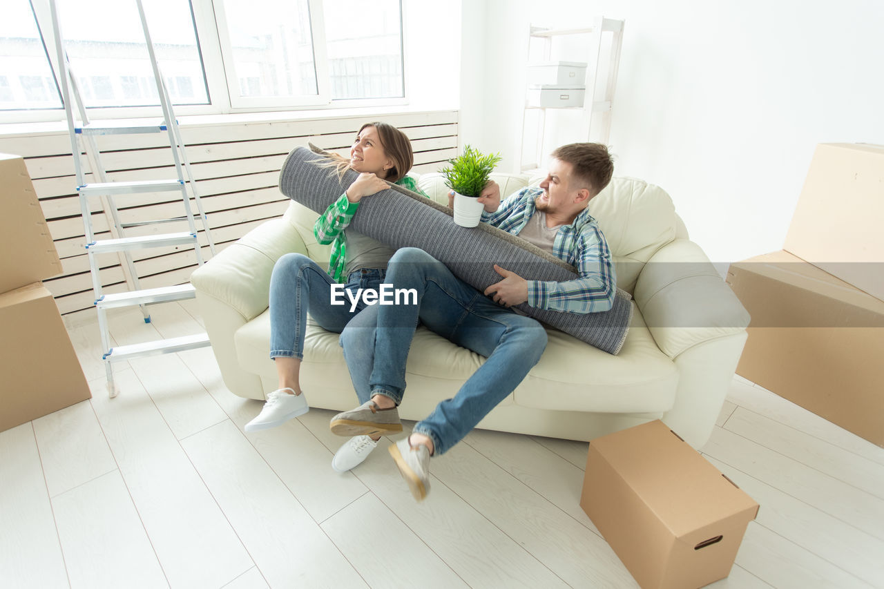COUPLE SITTING ON SOFA AT HOME