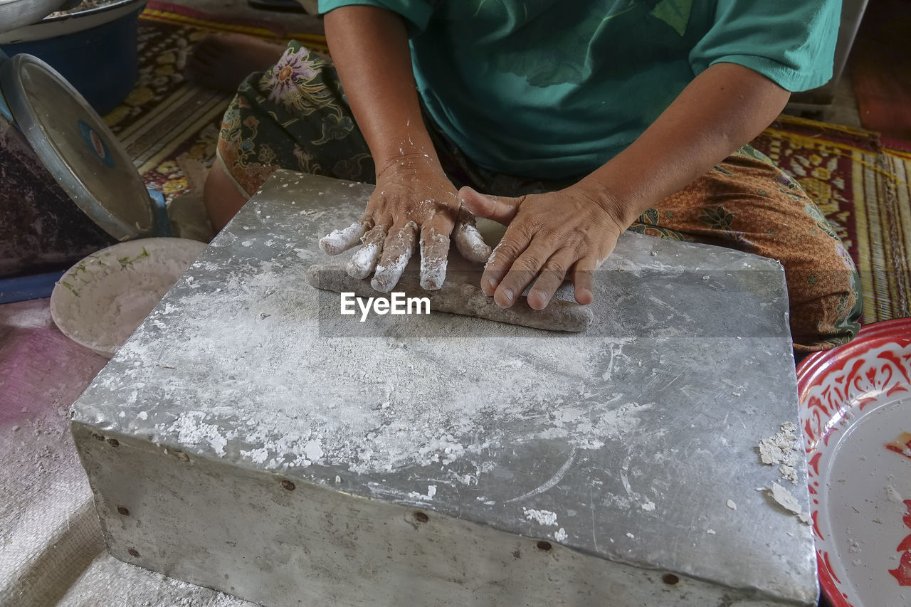 HIGH ANGLE VIEW OF MAN PREPARING FOOD IN MARKET