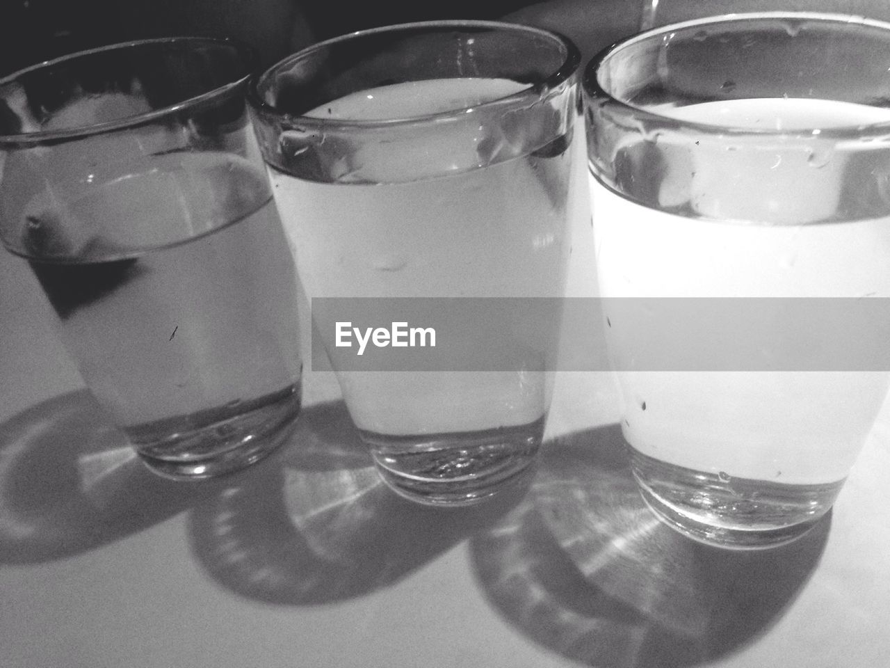 Close-up of drinking glasses filled with water served on table