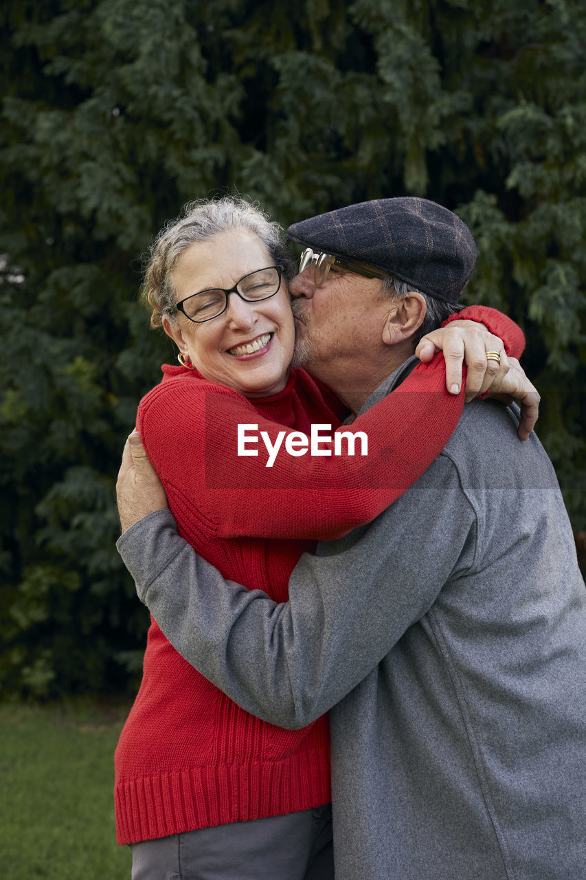 Old man kissing wife on the cheek