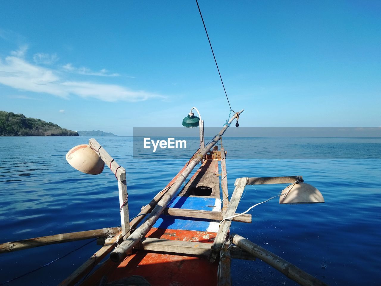 Fishing boat in sea against blue sky