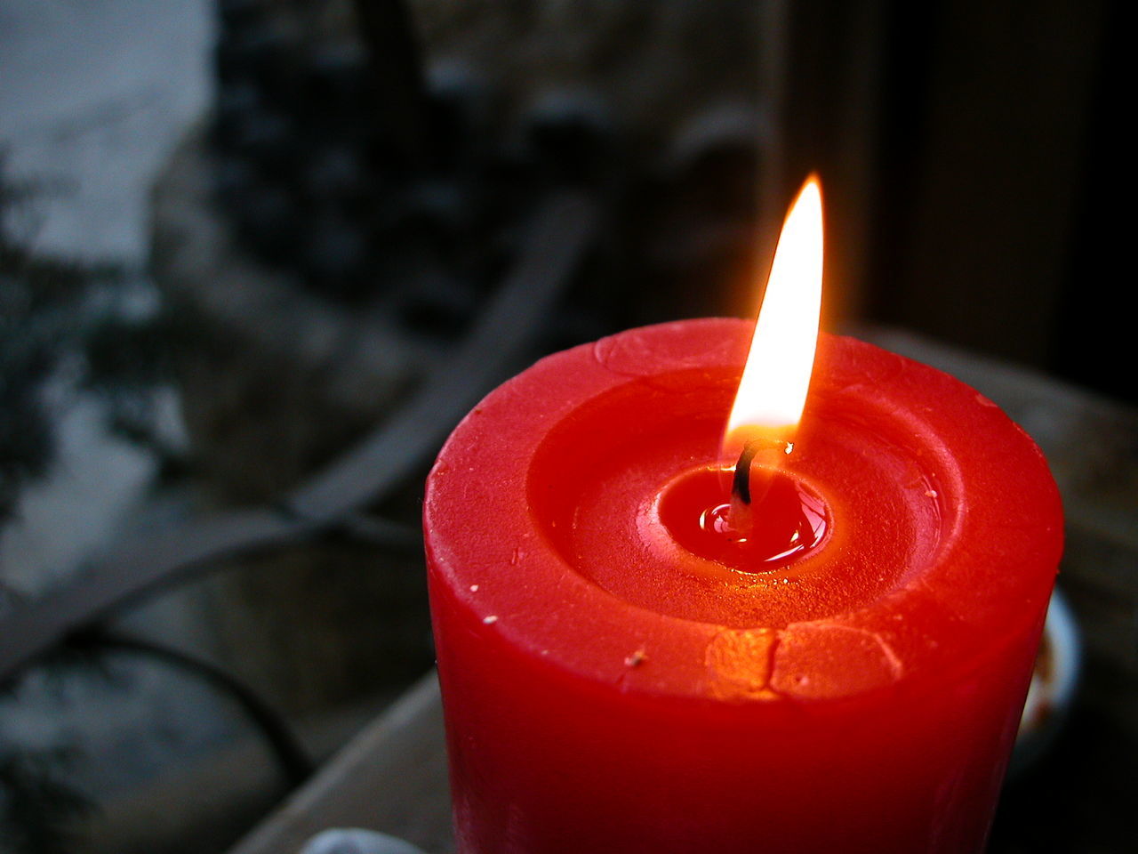 CLOSE-UP OF LIT CANDLE IN THE DARK