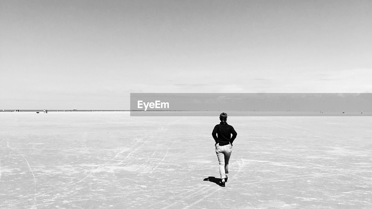 Rear view of woman walking on slat flat