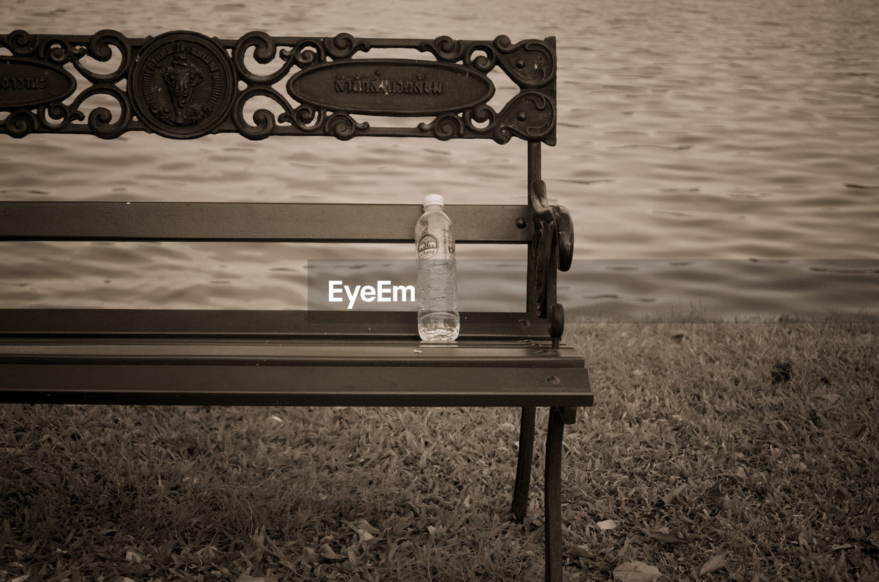 Water bottle on bench at lakeshore