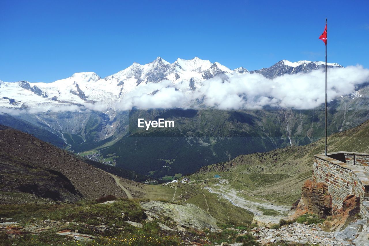 Scenic view of snowcapped mountains against clear blue sky