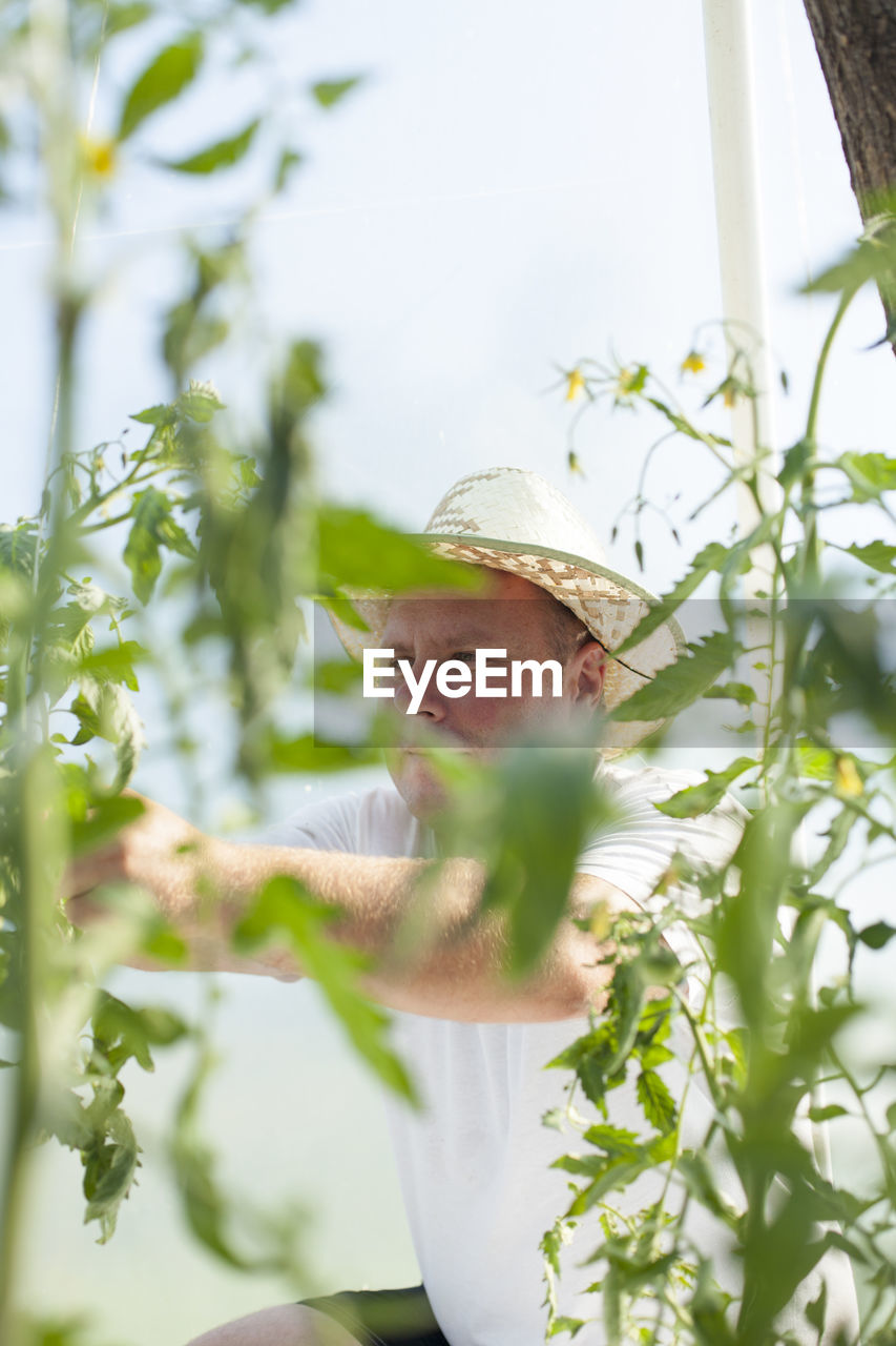 Man standing by flowering plants