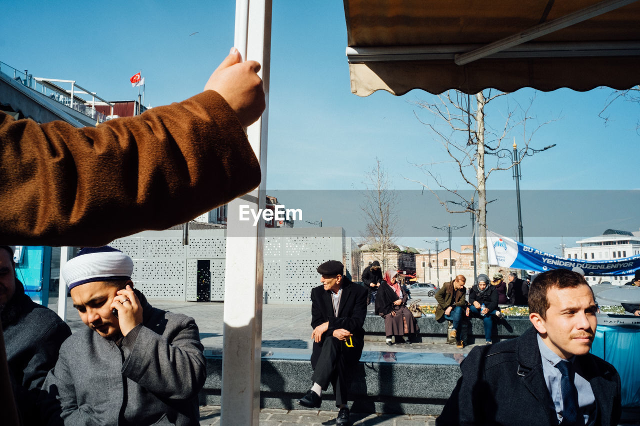 MEN STANDING ON STREET IN CITY