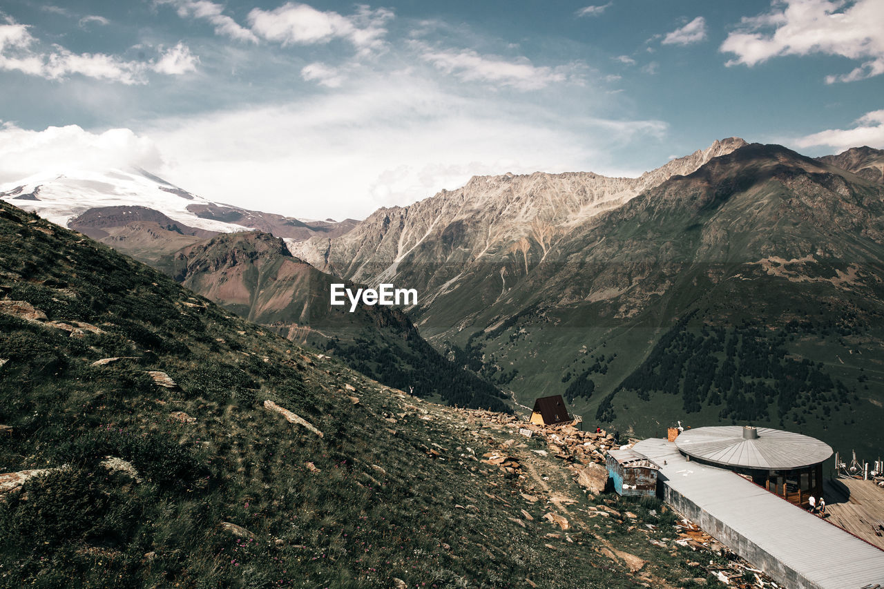 PEOPLE WALKING ON MOUNTAIN AGAINST SKY