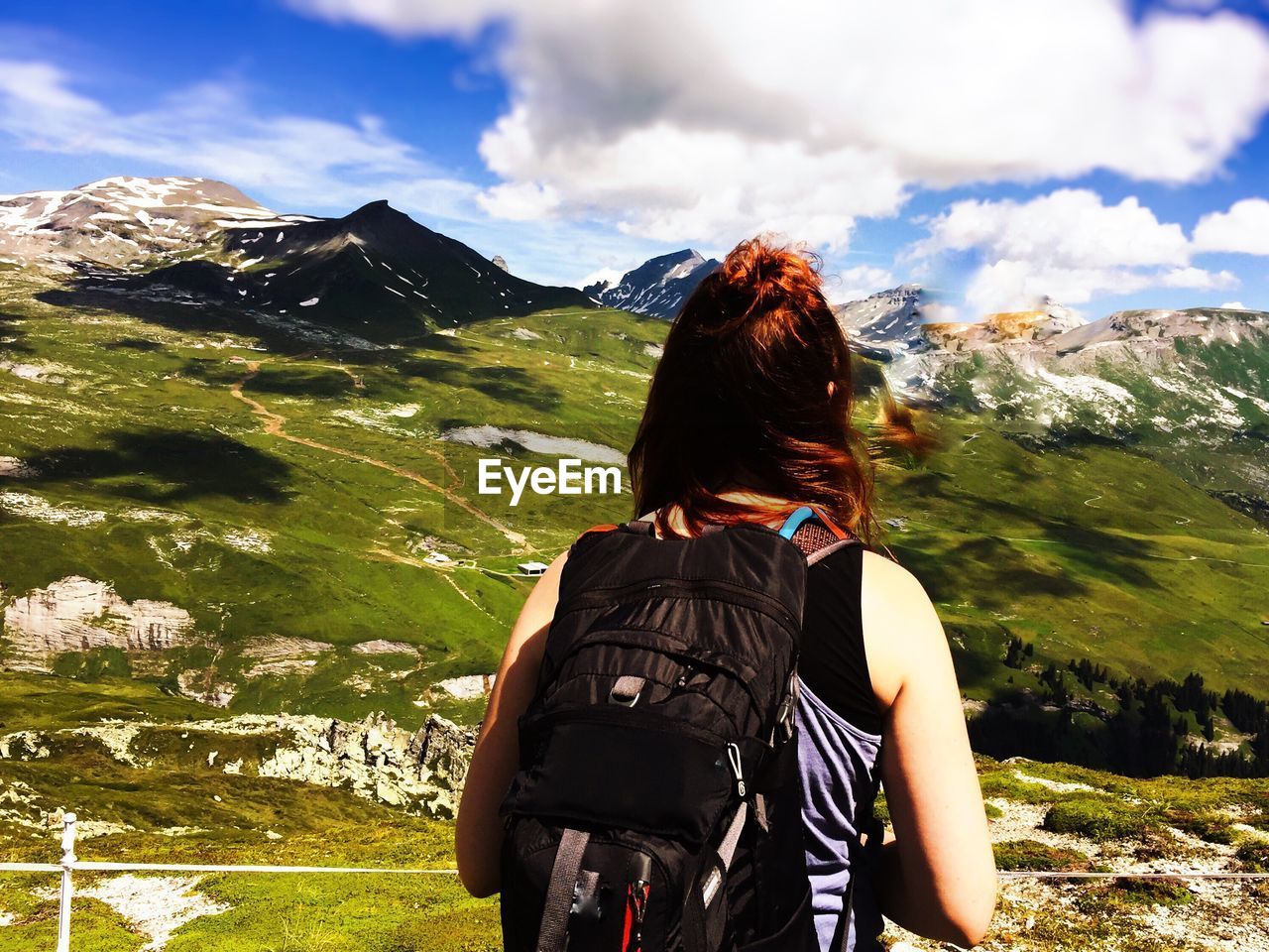 Rear view of hiker standing against mountain