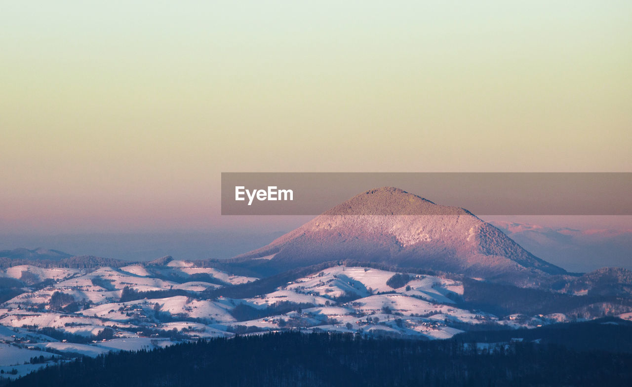 Scenic view of mountains against clear sky during winter