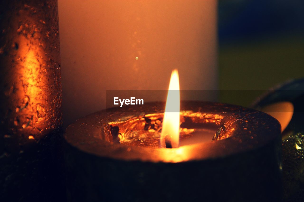 CLOSE-UP OF LIT CANDLES BURNING