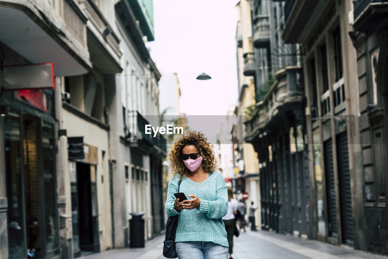 Portrait of woman standing on street in city