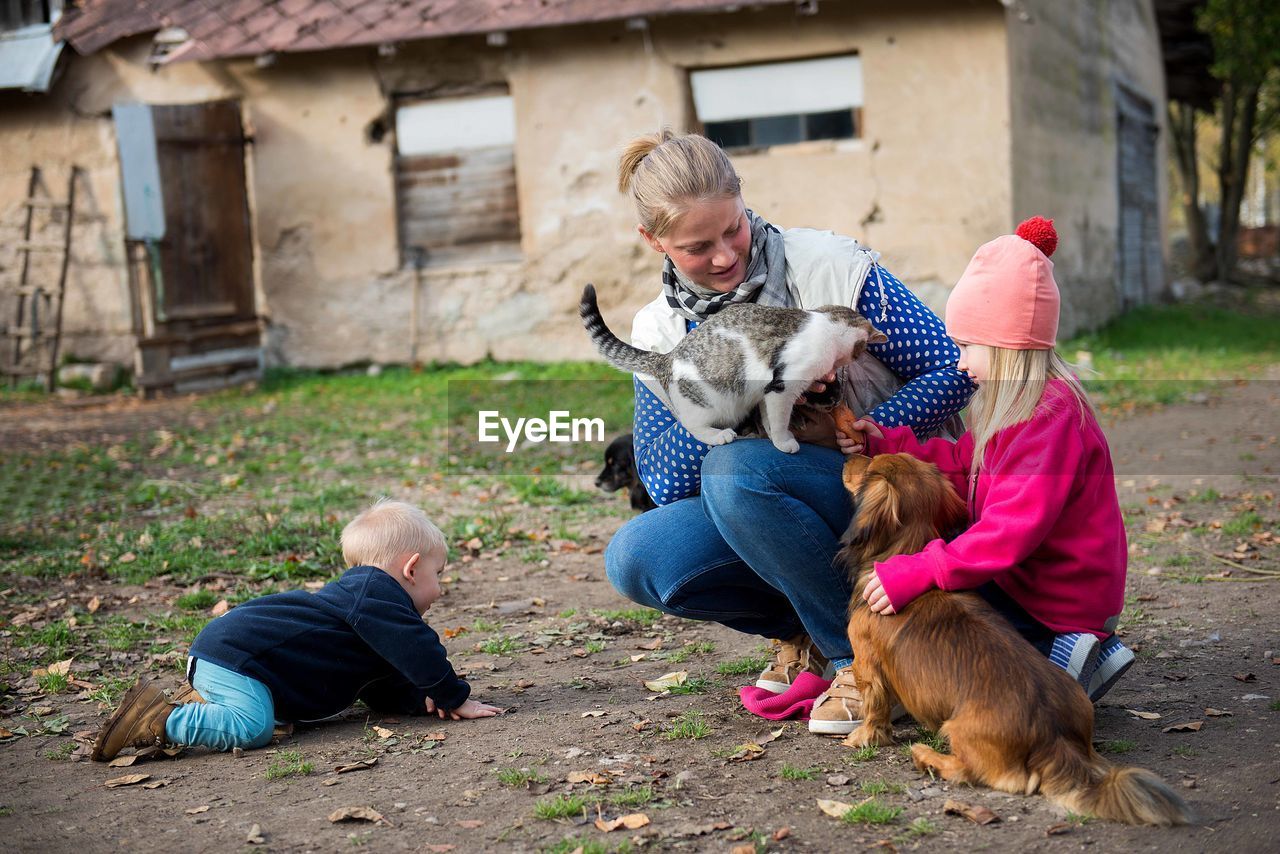 REAR VIEW OF PEOPLE WITH DOG ON THE FLOOR