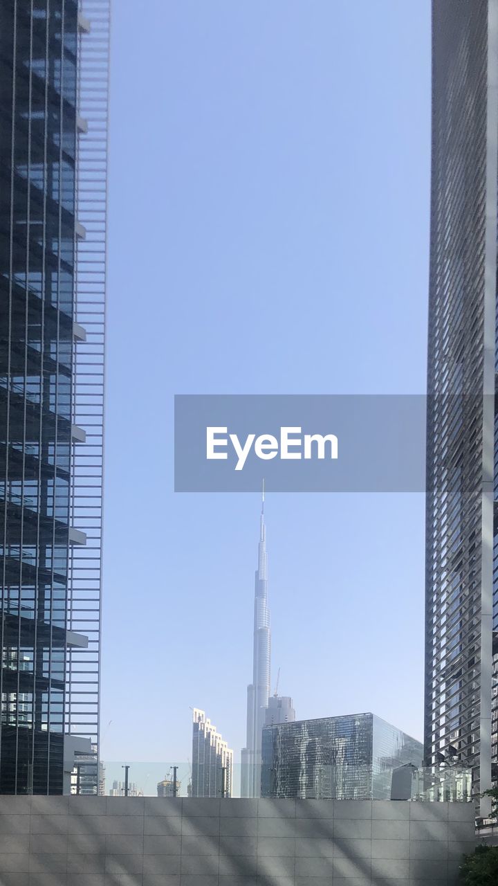 LOW ANGLE VIEW OF BUILDINGS IN CITY AGAINST CLEAR SKY