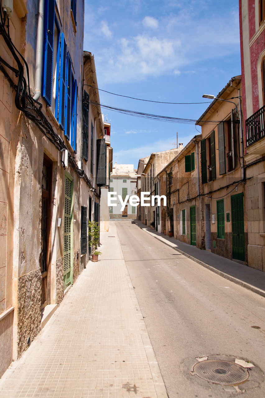 Empty road amidst buildings in town, mallorca 