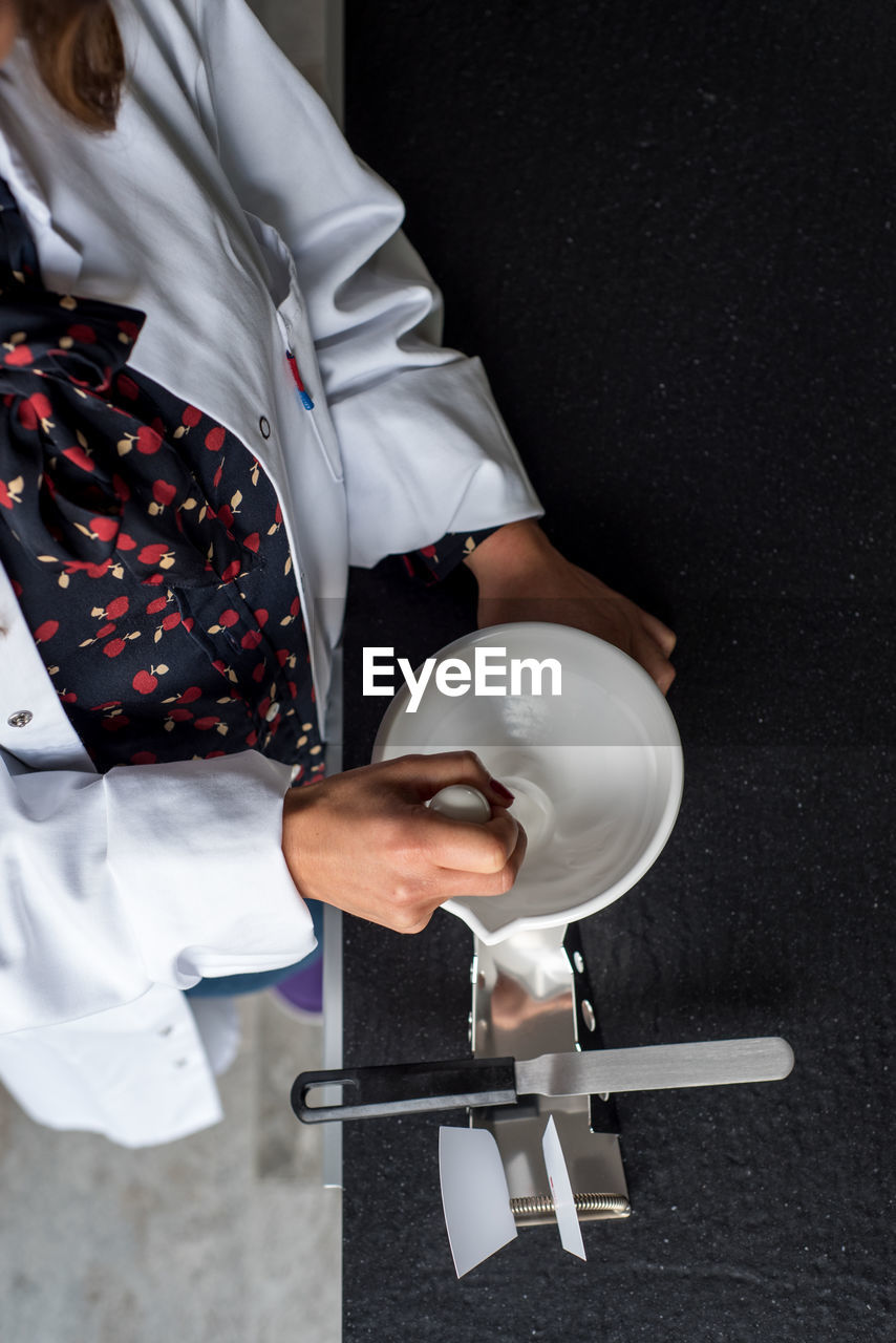 Midsection of female scientist preparing medicine in laboratory