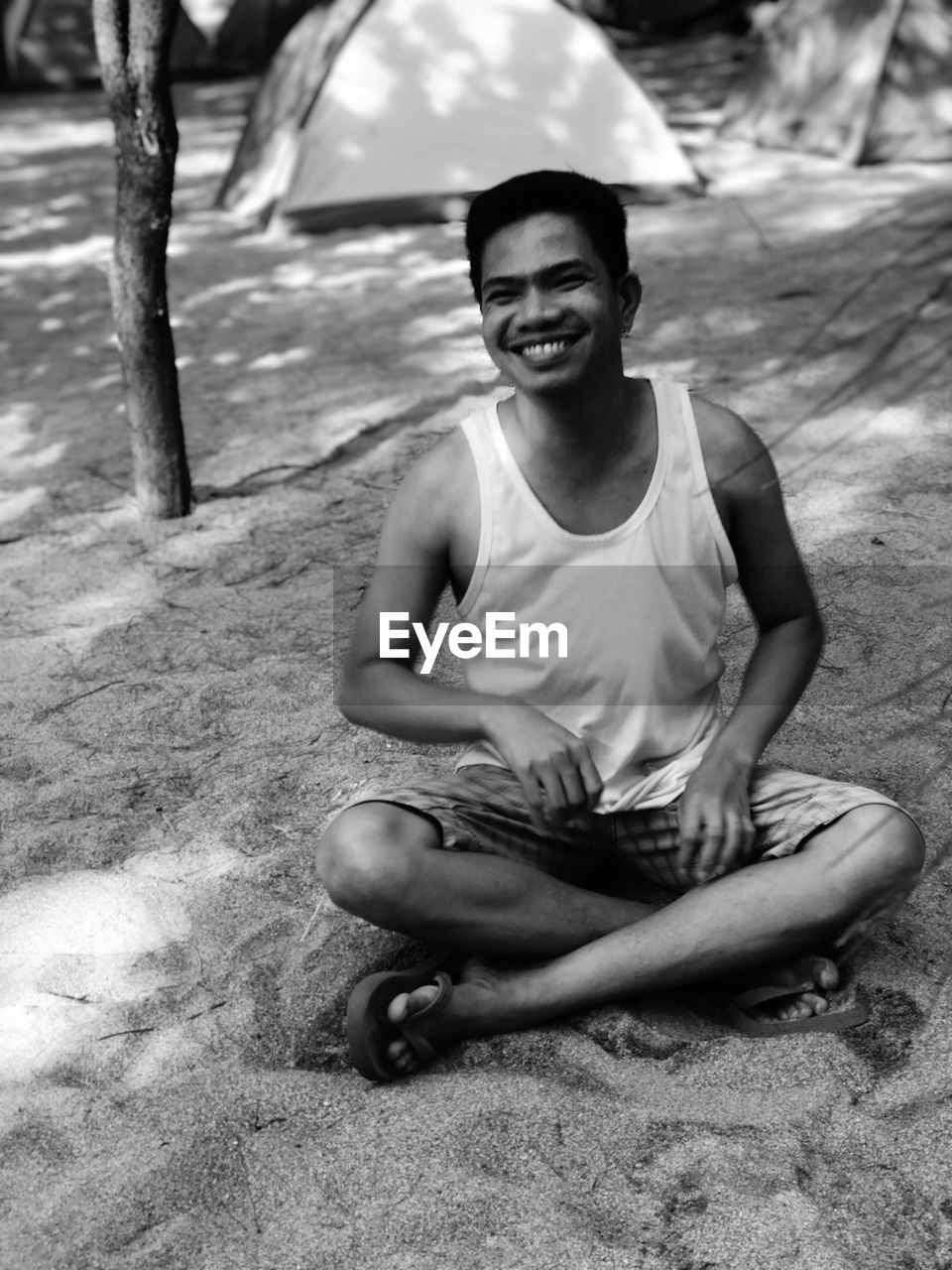 Portrait of smiling man sitting on sand