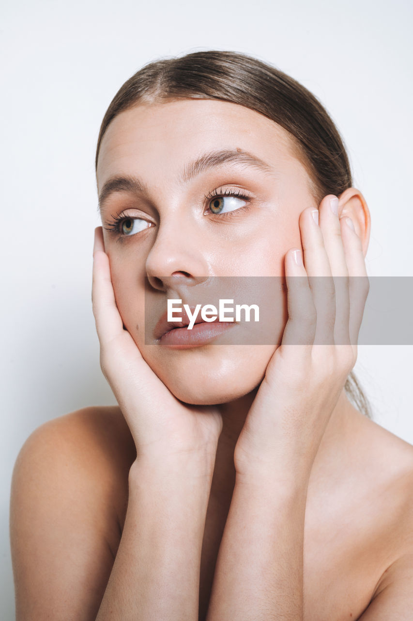 Close up beauty portrait of young girl with fresh skin tone on white background