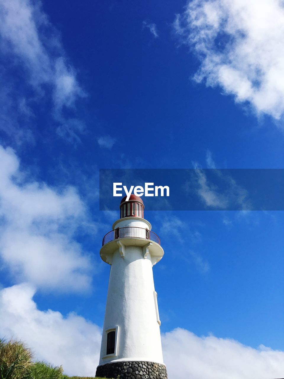 LOW ANGLE VIEW OF LIGHTHOUSE AGAINST BUILDING AND SKY