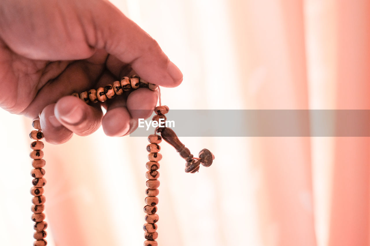 Close-up of hand holding prayer beads