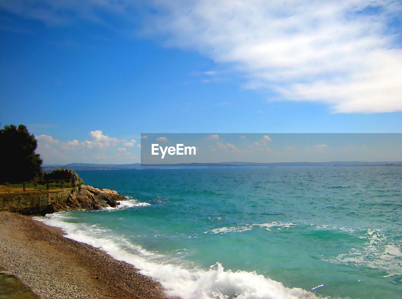 SCENIC VIEW OF BEACH AGAINST BLUE SKY