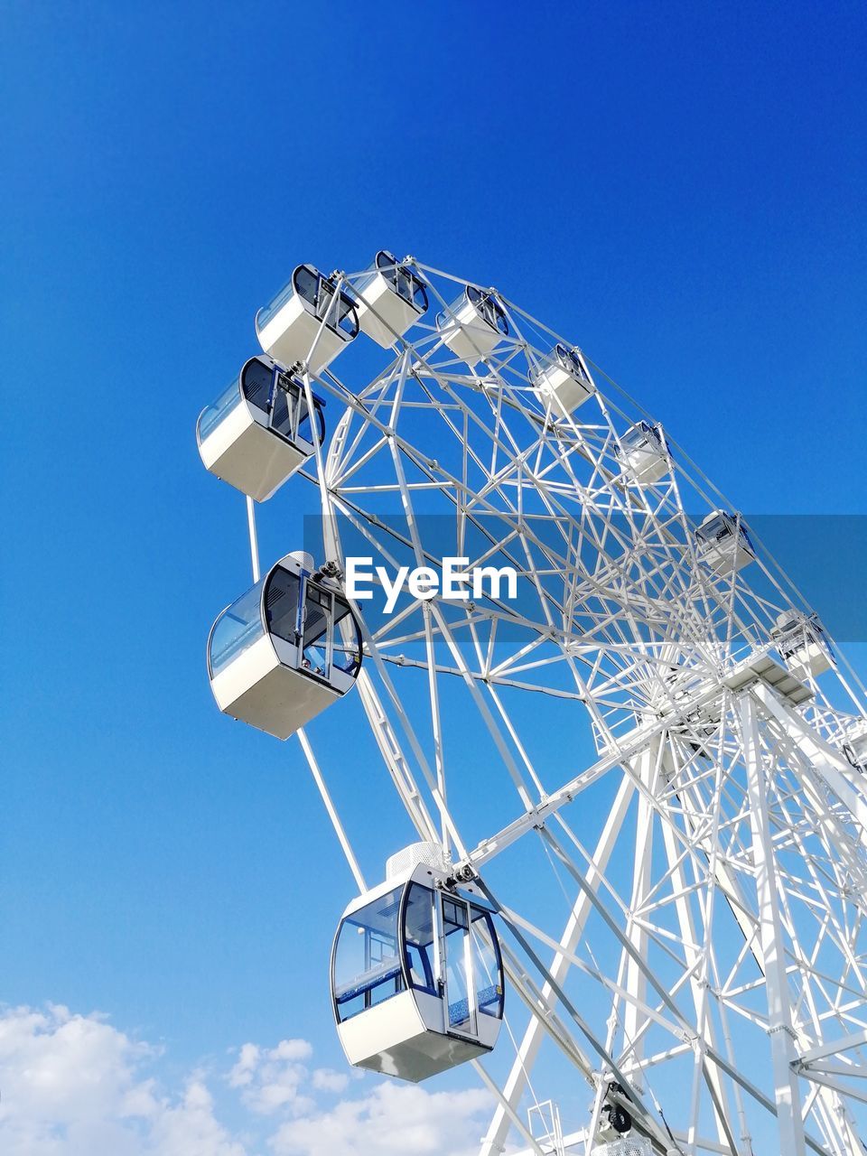 Low angle view of ferris wheel against blue sky