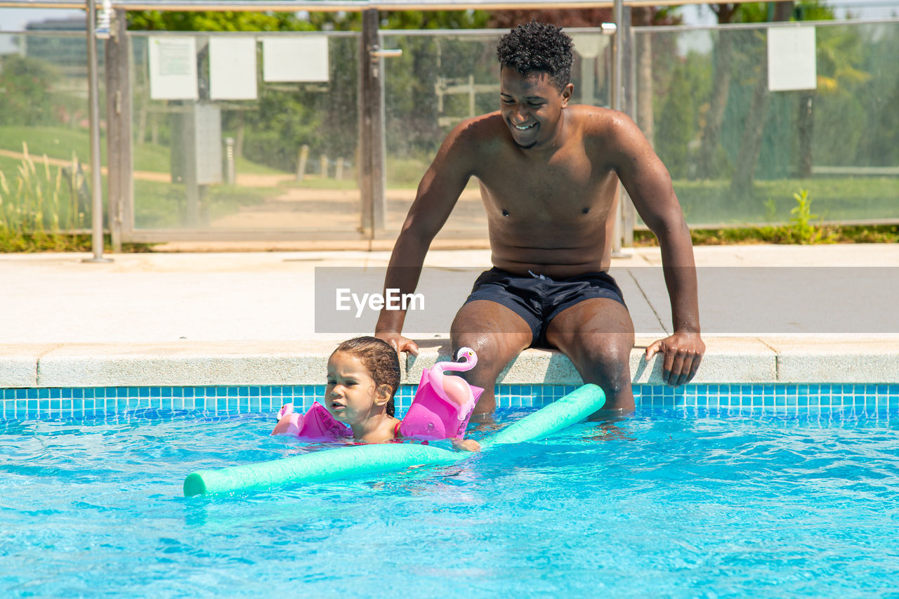 Father and daughter having fun in pool