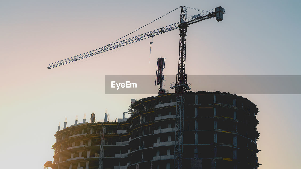 LOW ANGLE VIEW OF CRANE AT CONSTRUCTION SITE