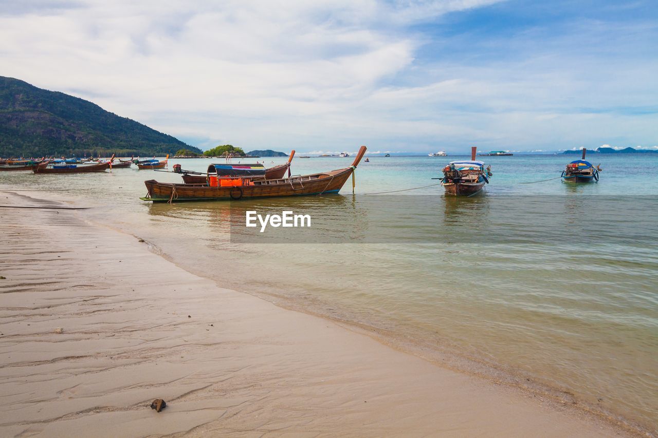 Boats moored on sea against sky