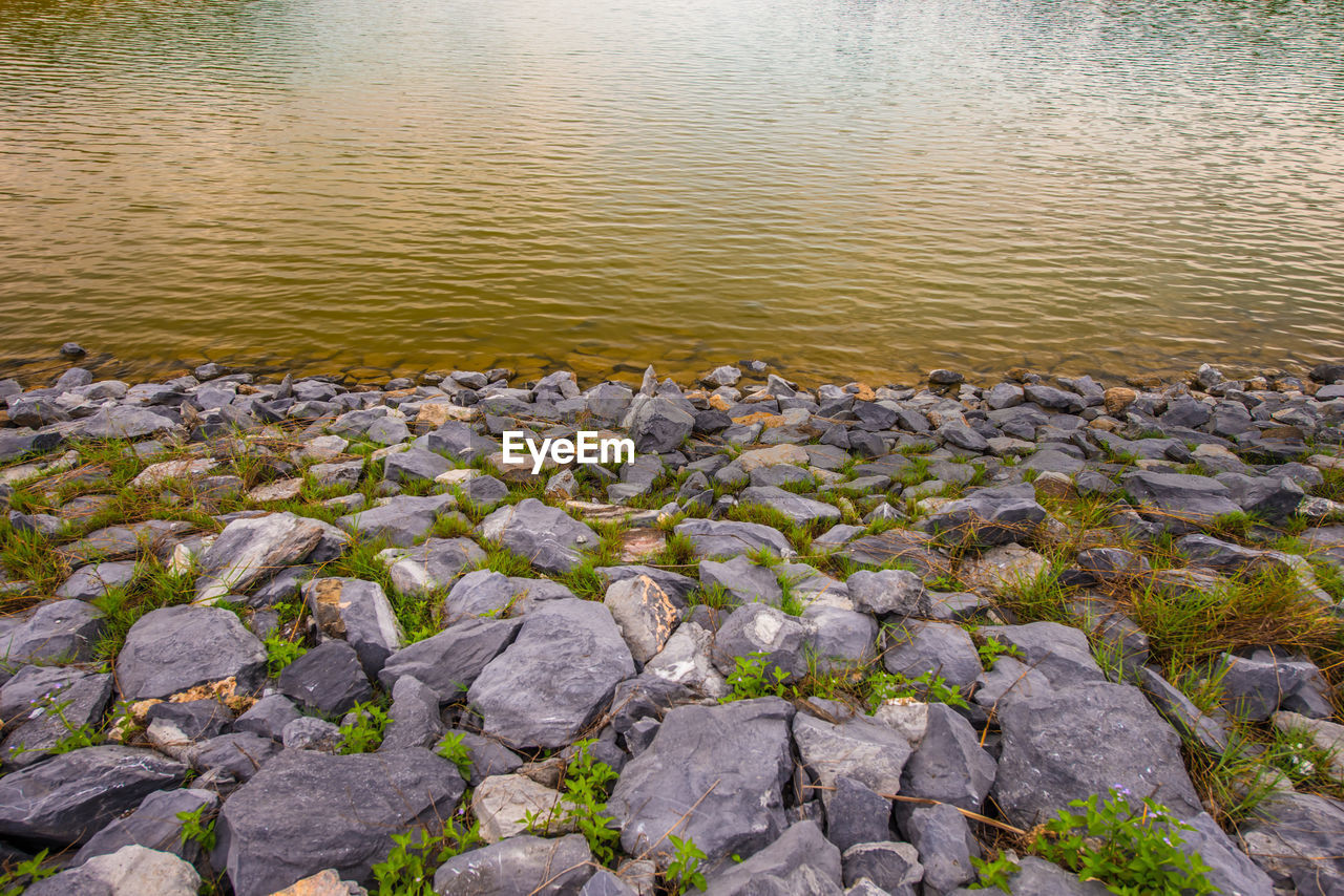 HIGH ANGLE VIEW OF STONES ON SHORE