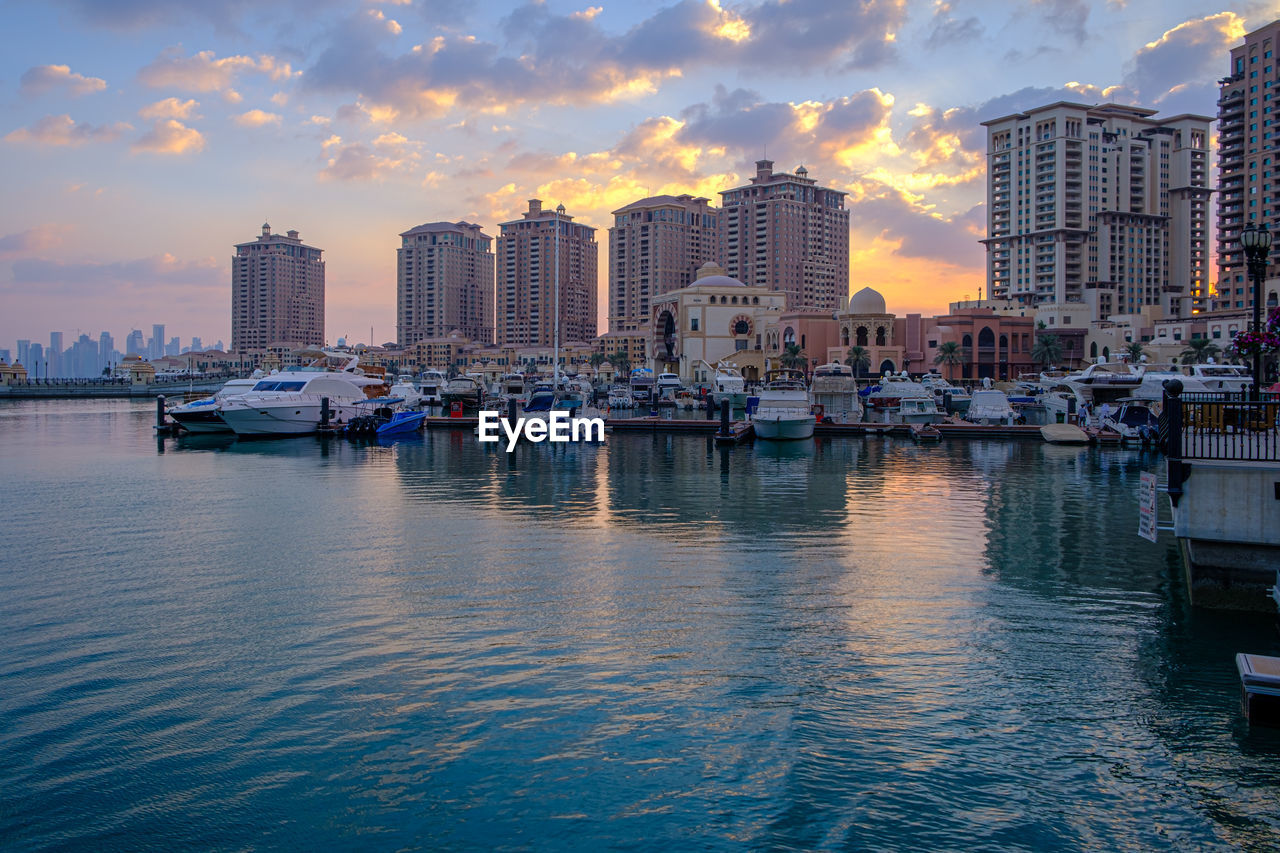 VIEW OF SEA AND BUILDINGS AGAINST SKY DURING SUNSET