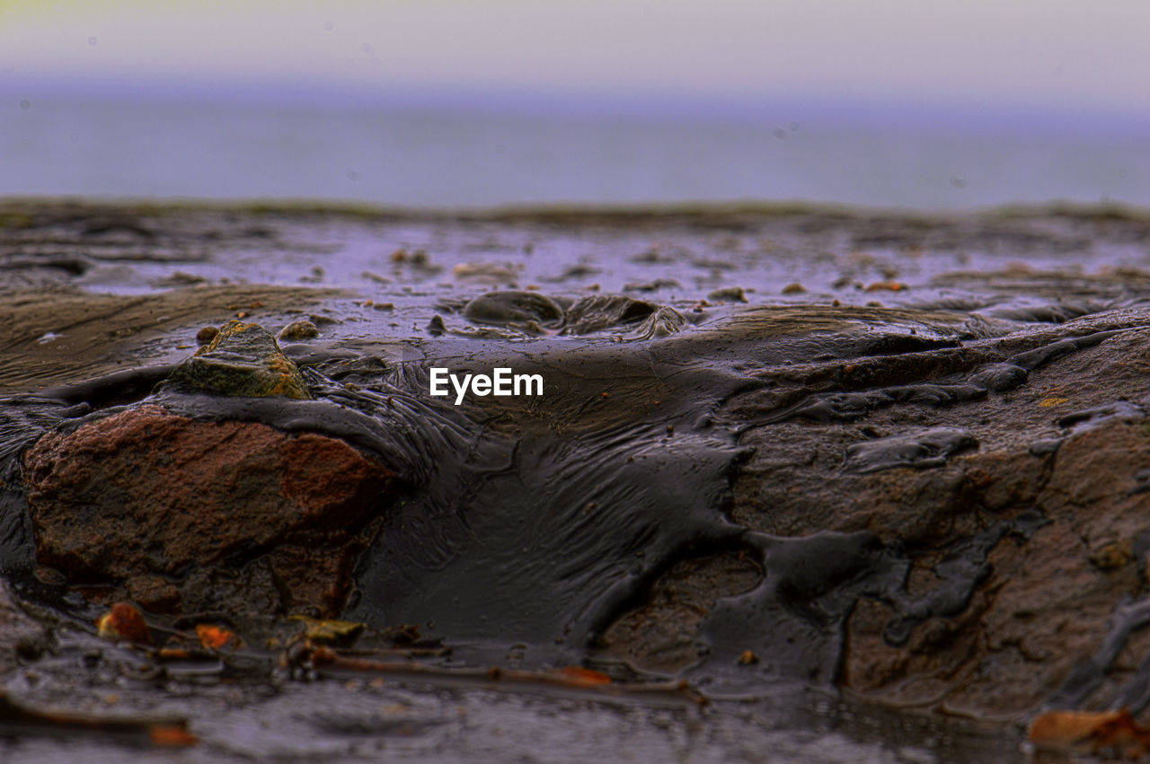 CLOSE-UP OF ROCKS ON SHORE