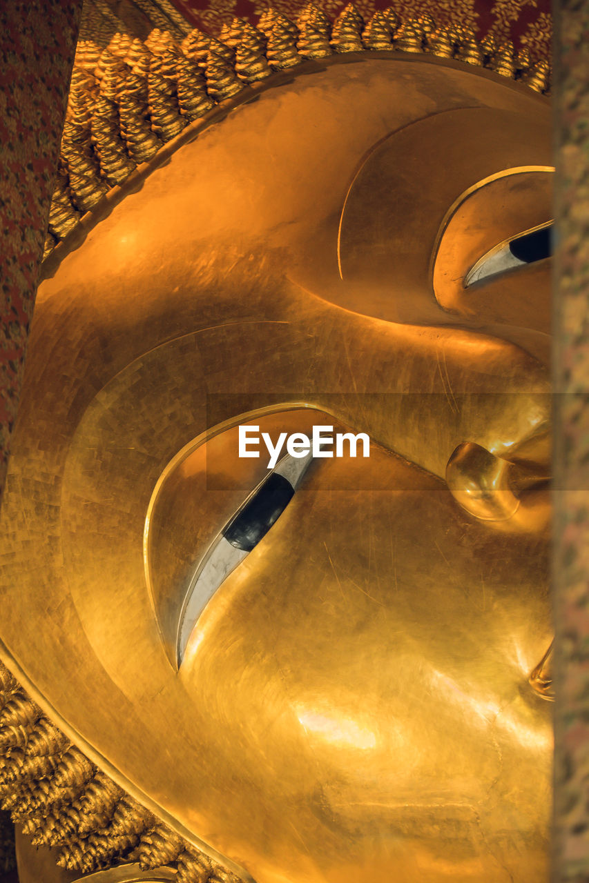 CLOSE-UP OF BUDDHA STATUE AT TEMPLE