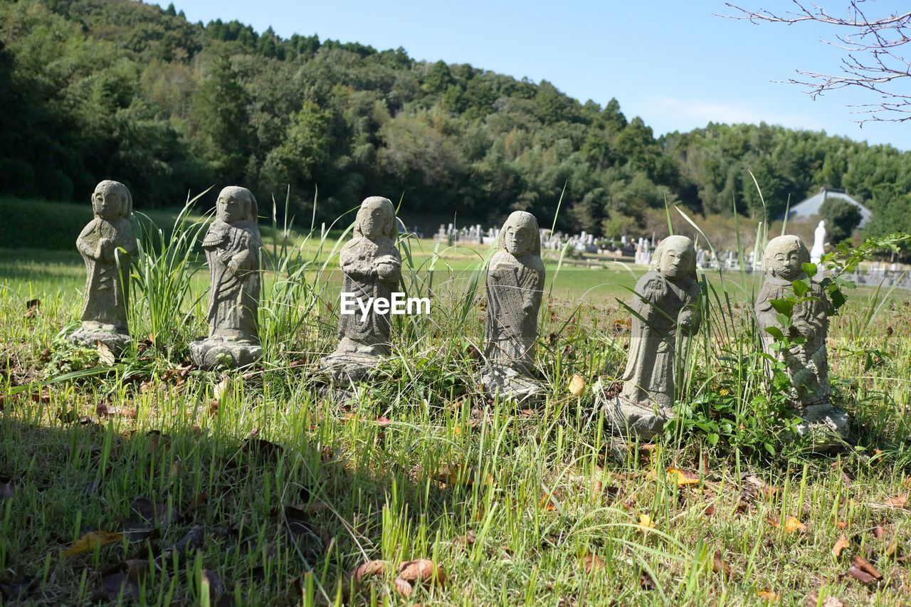 STATUES IN CEMETERY AGAINST SKY