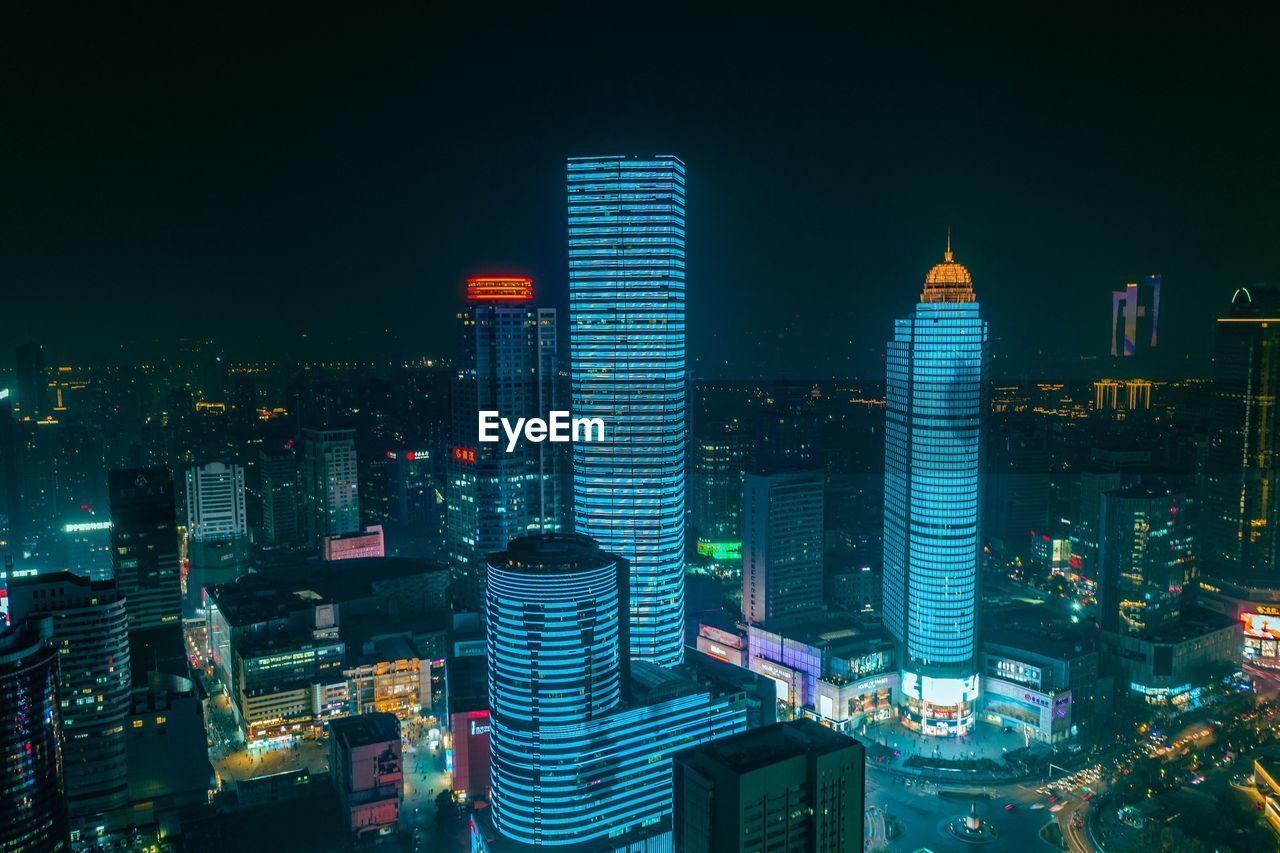 AERIAL VIEW OF ILLUMINATED BUILDINGS IN CITY AT NIGHT