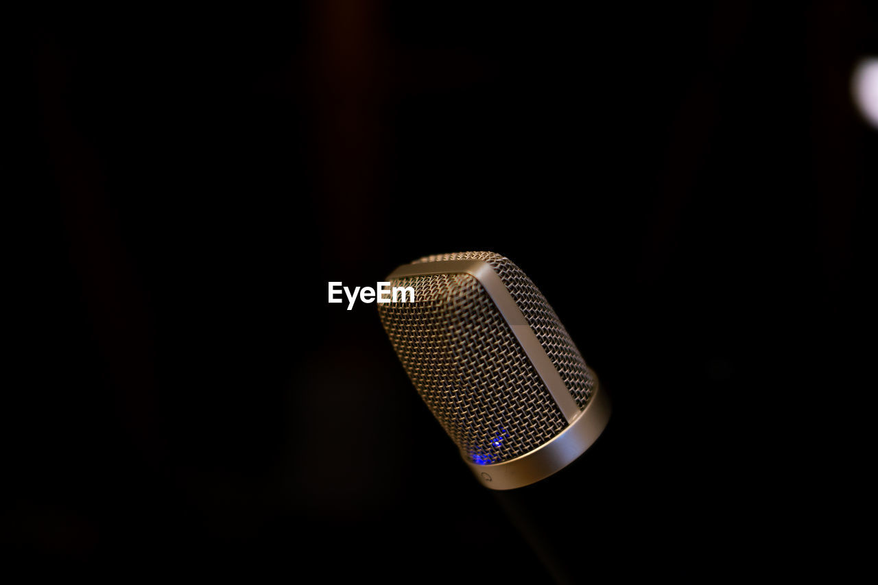 Close-up of microphone against black background
