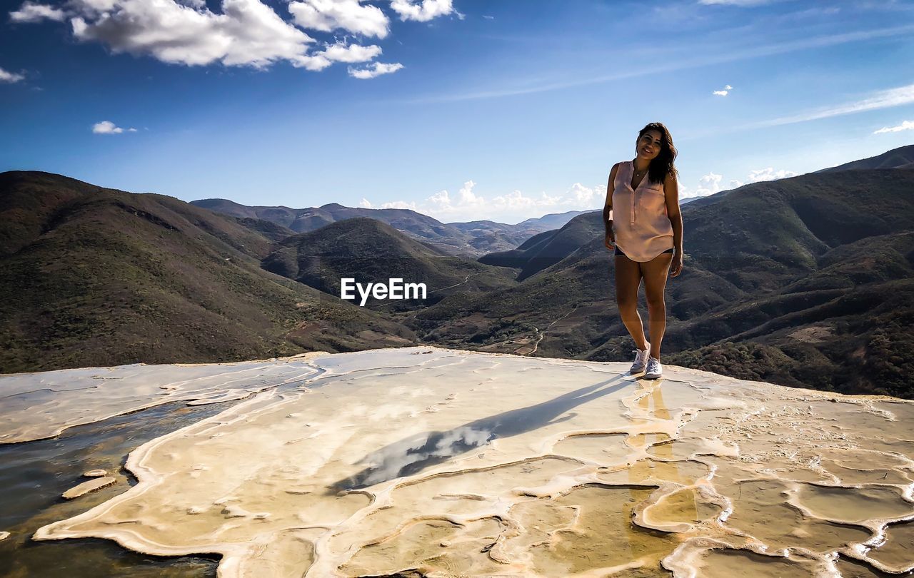 Portrait of woman standing on mountain against sky