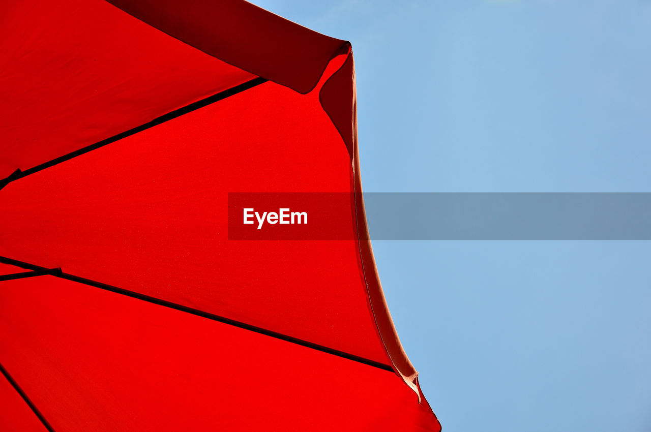 Low angle view of umbrella against blue sky