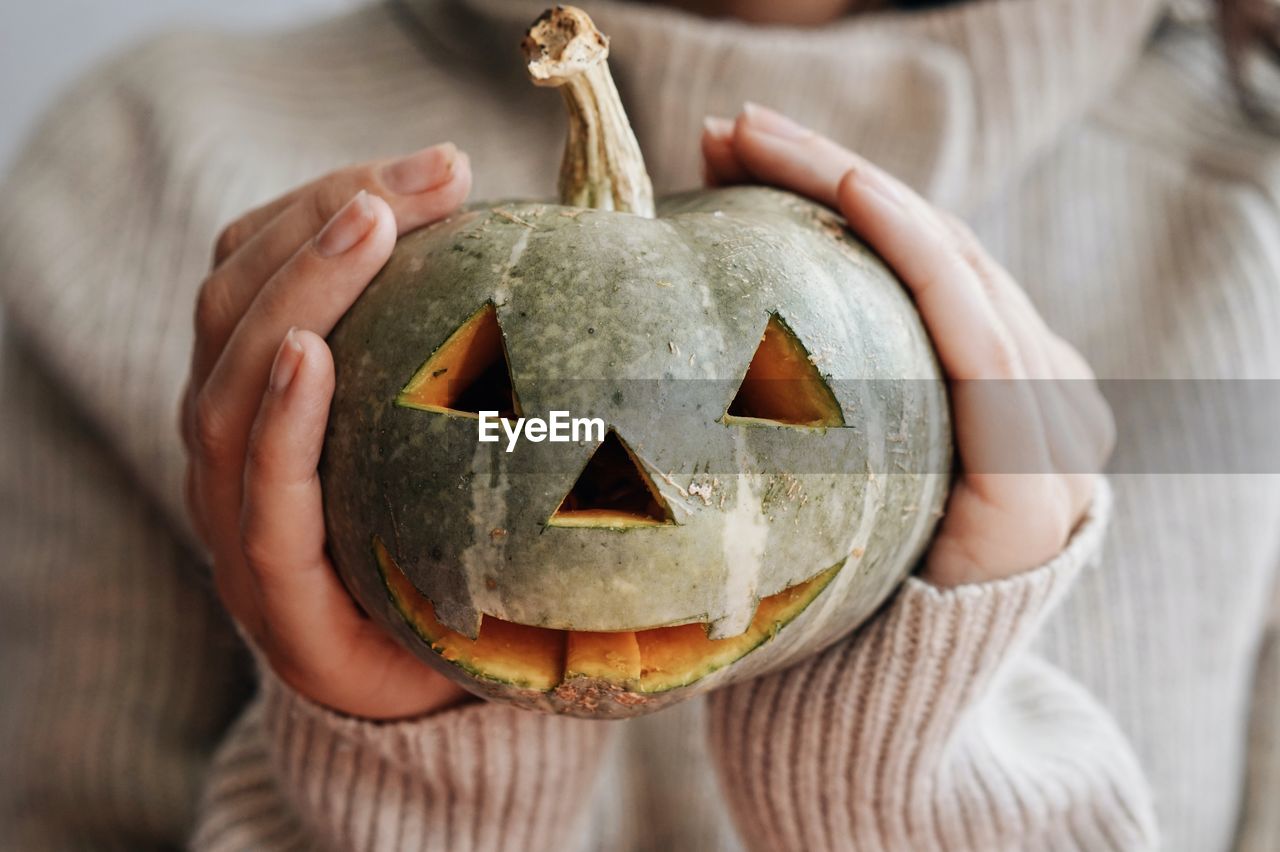 Midsection of woman holding pumpkin