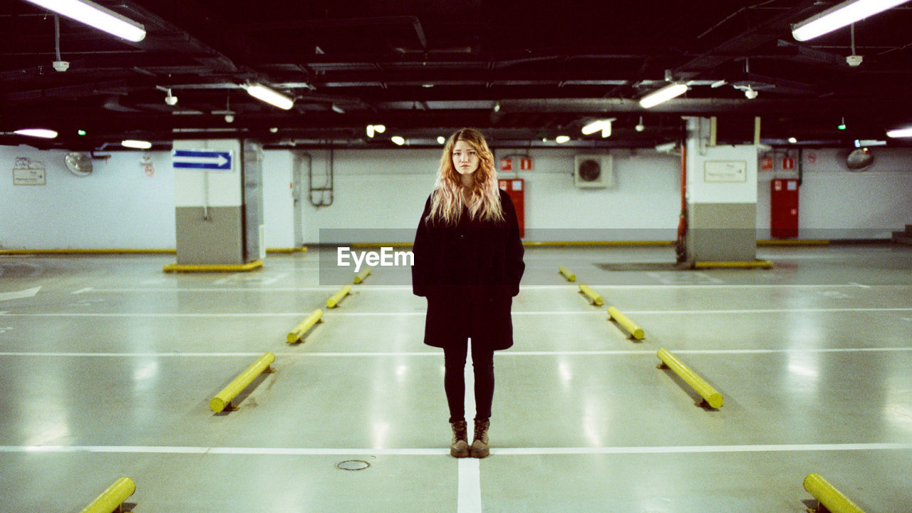 Portrait of a woman who stands in an underground parking lot