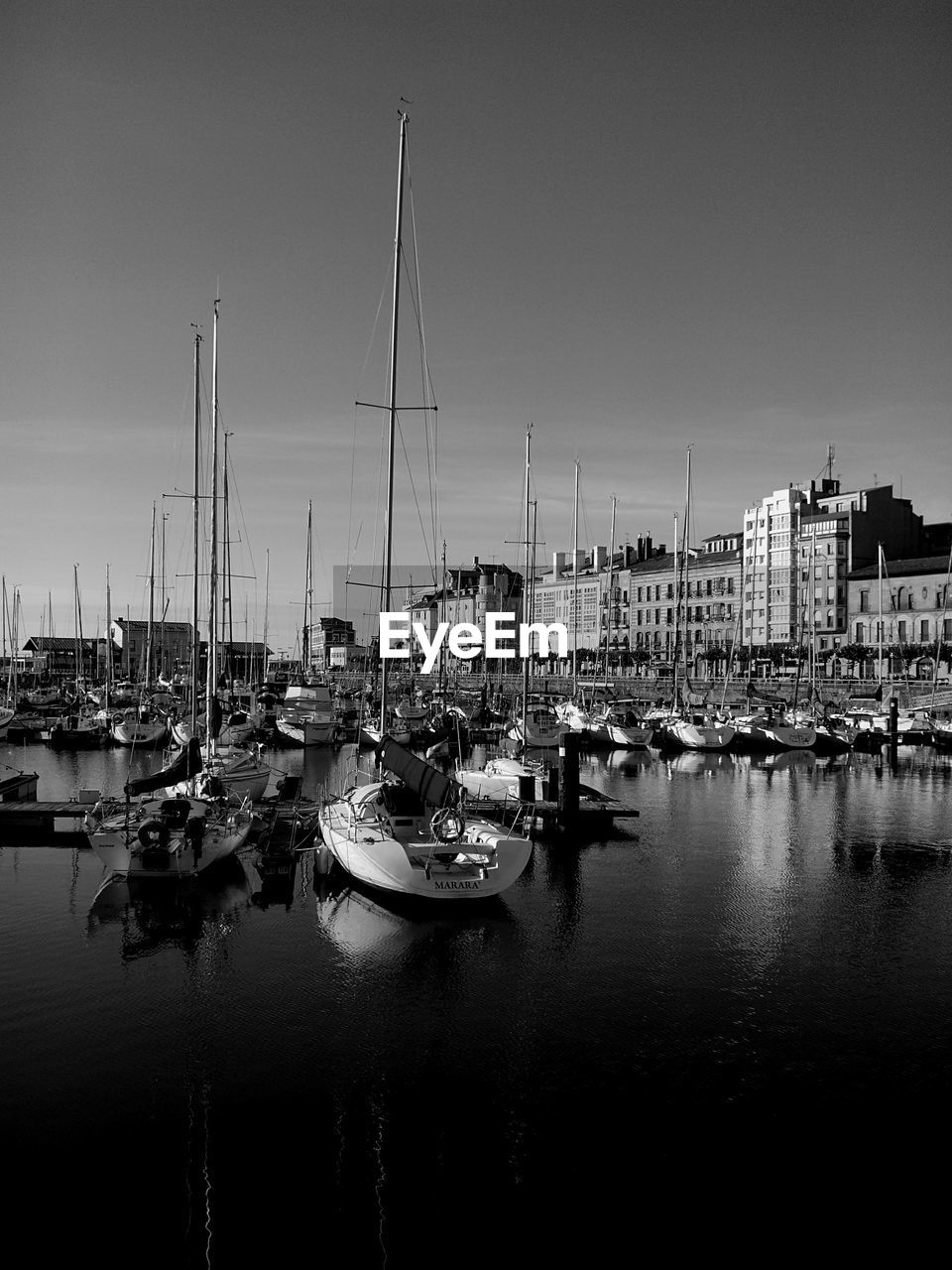 Sailboats moored in sea against clear sky