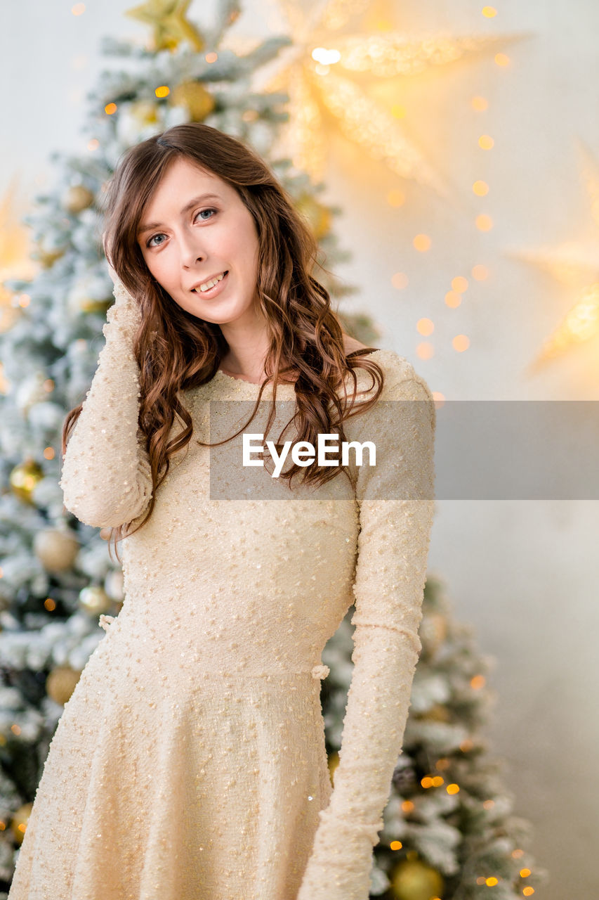 Beautiful girl at the christmas tree. girl with long hair. girl with styling and makeup. 